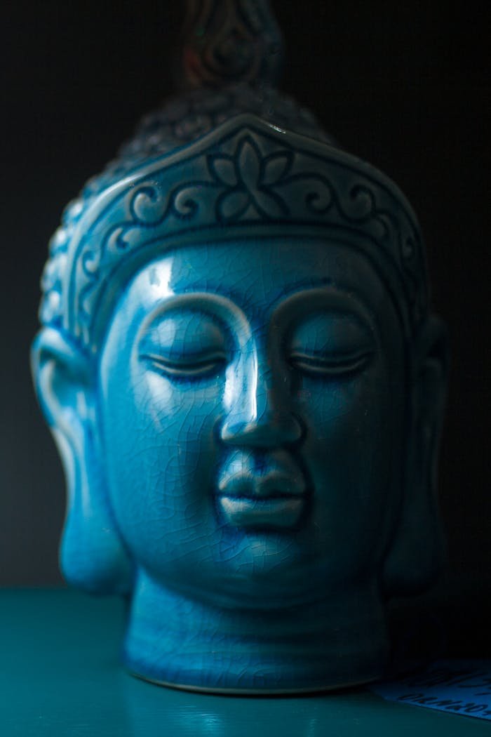 Close-up view of a blue ceramic Buddha head sculpture symbolizing peace and spirituality.